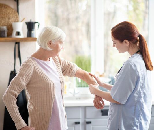 Nurse Holding Elder Lady's Arm in Kitchen Assisting with Elder Care in Wexford, PA