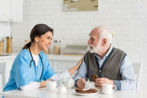 Caregivers for Seniors Talking to Elderly Man at Kitchen Table in Pittsburgh