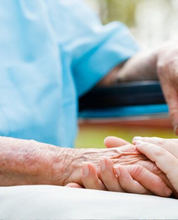 In Home Health Care Services Professional Holding Elderly Man's Hand in Pittsburgh, PA